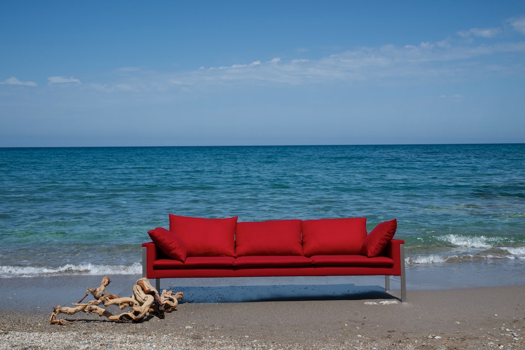 red padded couch on beach shore during daytime