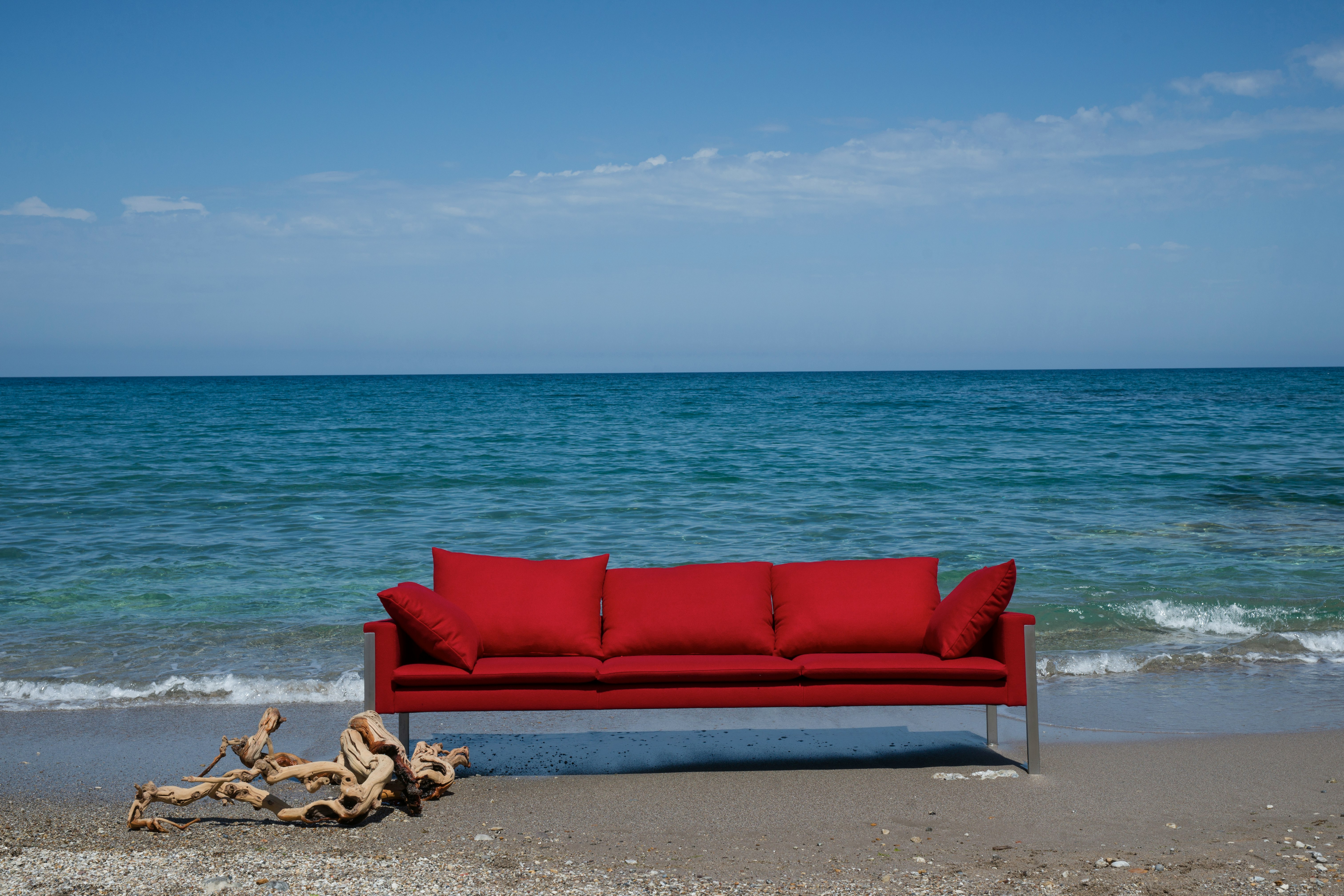 red padded couch on beach shore during daytime