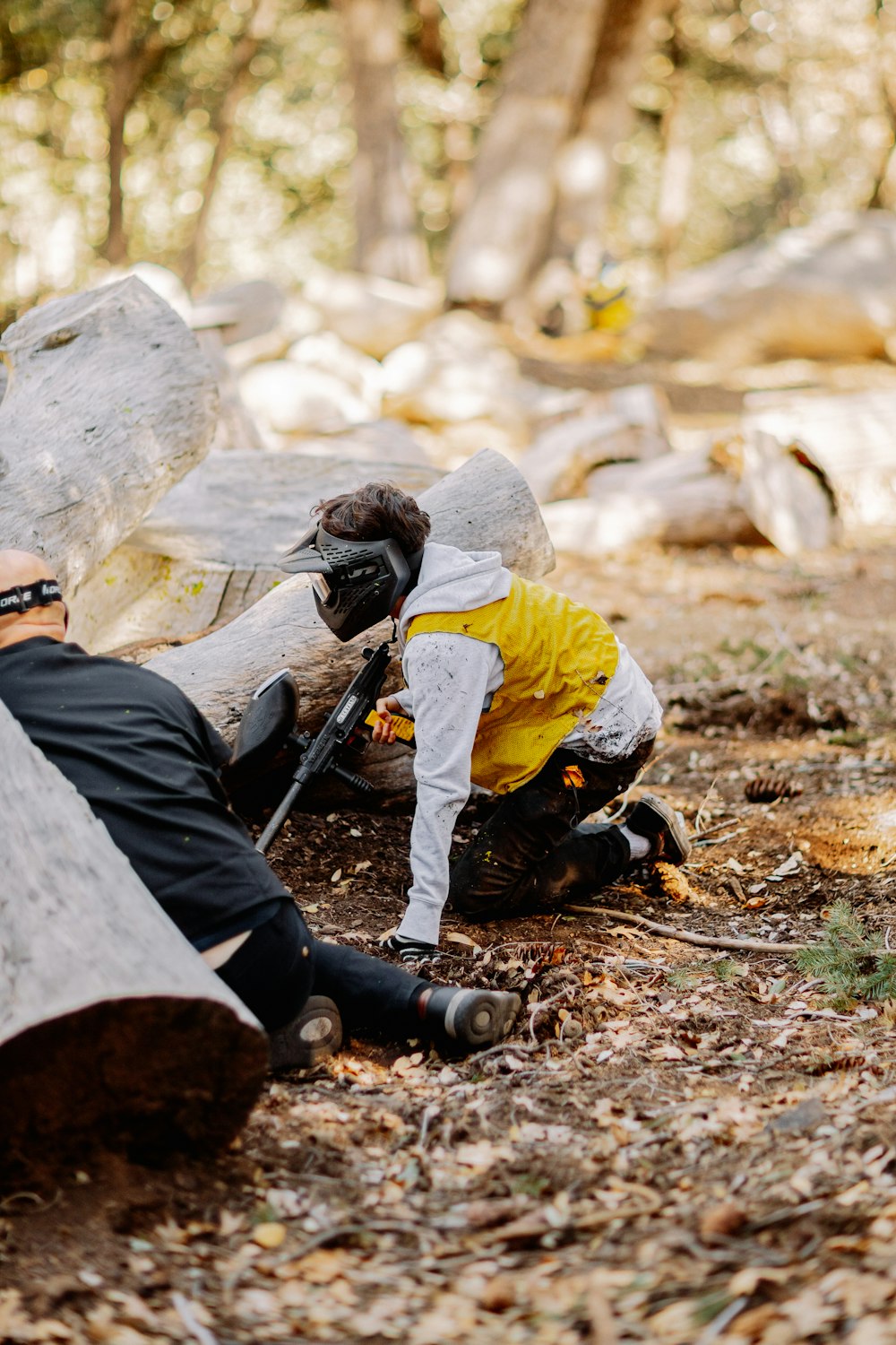 man in black and yellow jacket sitting on ground