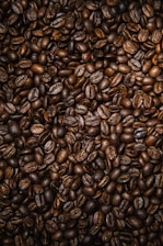 brown coffee beans on black surface