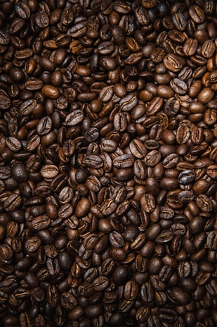 brown coffee beans on black surface