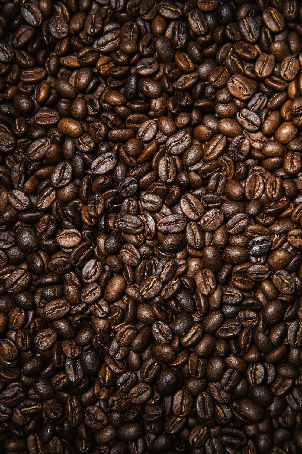 Granos de café marrón sobre superficie negra