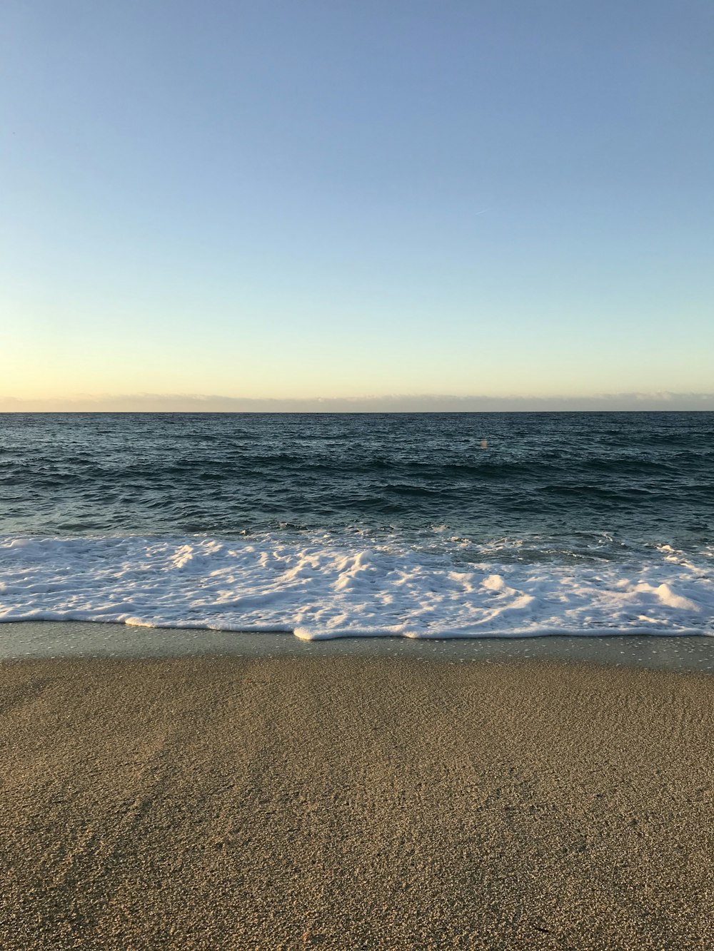 sea waves crashing on shore during daytime