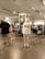 A clothing store interior with several mannequins displaying casual wear. The foreground mannequin is dressed in a cream-colored sweatshirt with 'YALE' printed on it, paired with matching pants and white sneakers. Garment racks filled with various clothing items are visible in the background along with store signage.
