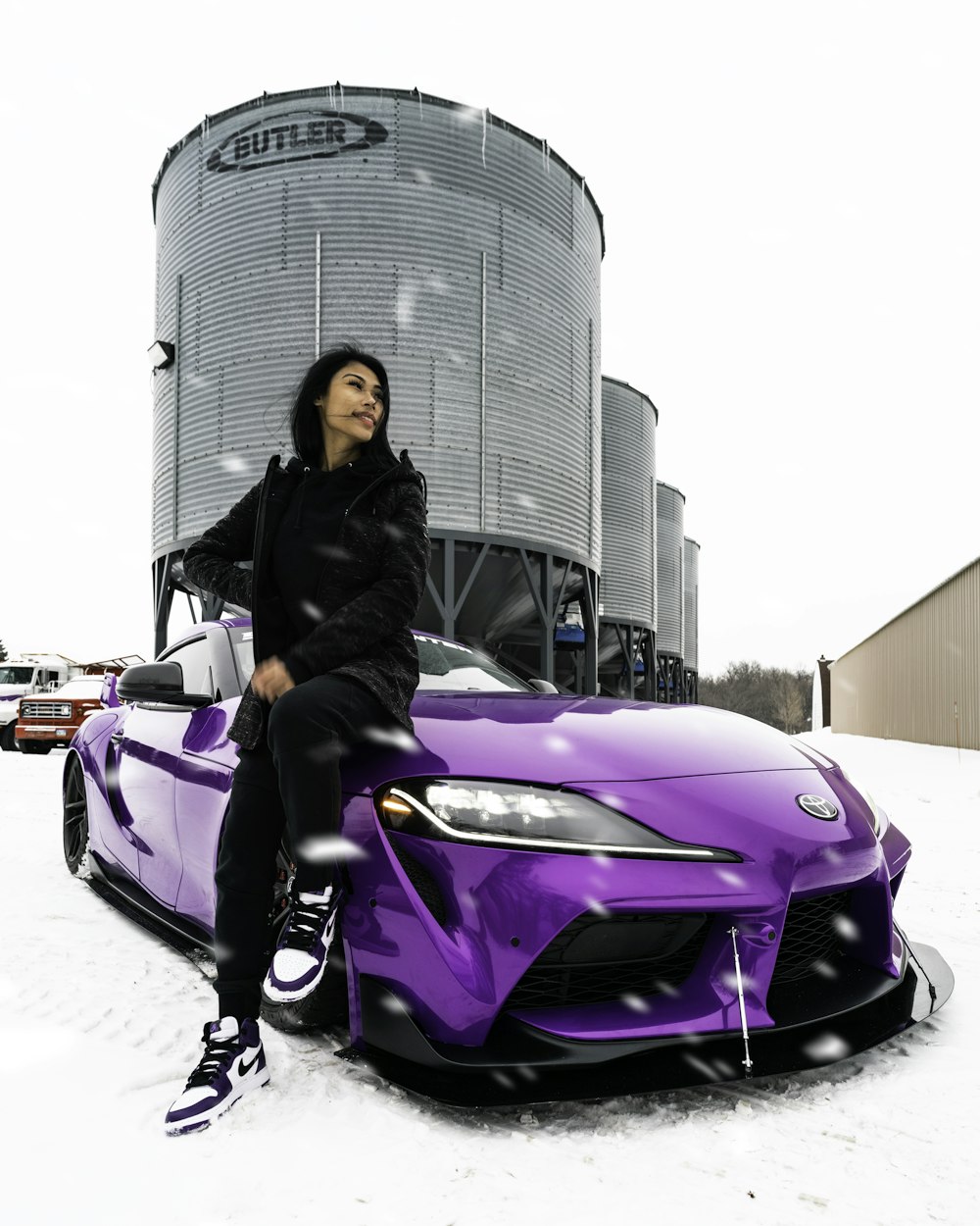 woman in black jacket sitting on purple car