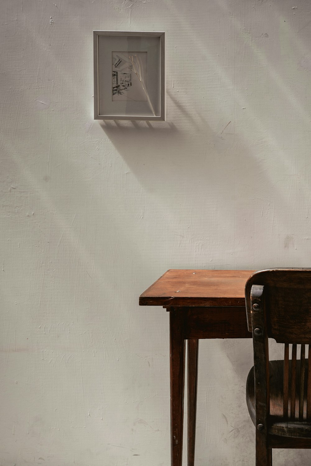 brown wooden table beside white wall