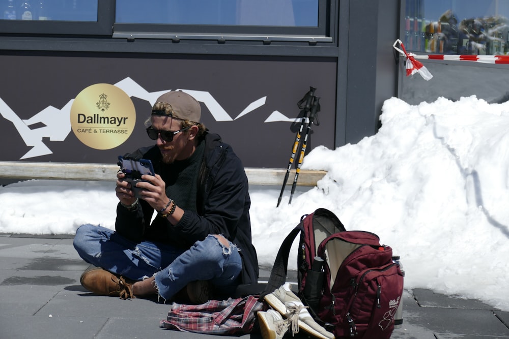 man in black jacket holding black dslr camera