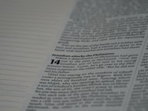 A close-up of a page from a Bible focusing on a passage about Jonathan attacking the Philistines, with text in black font on a white background.