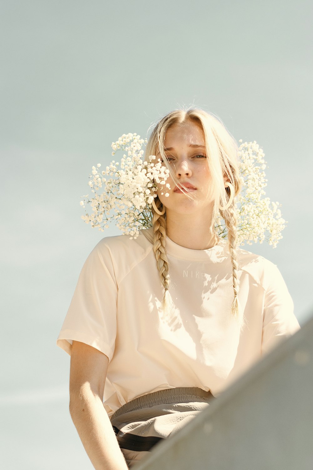 femme en chemise blanche avec des fleurs blanches sur l'oreille