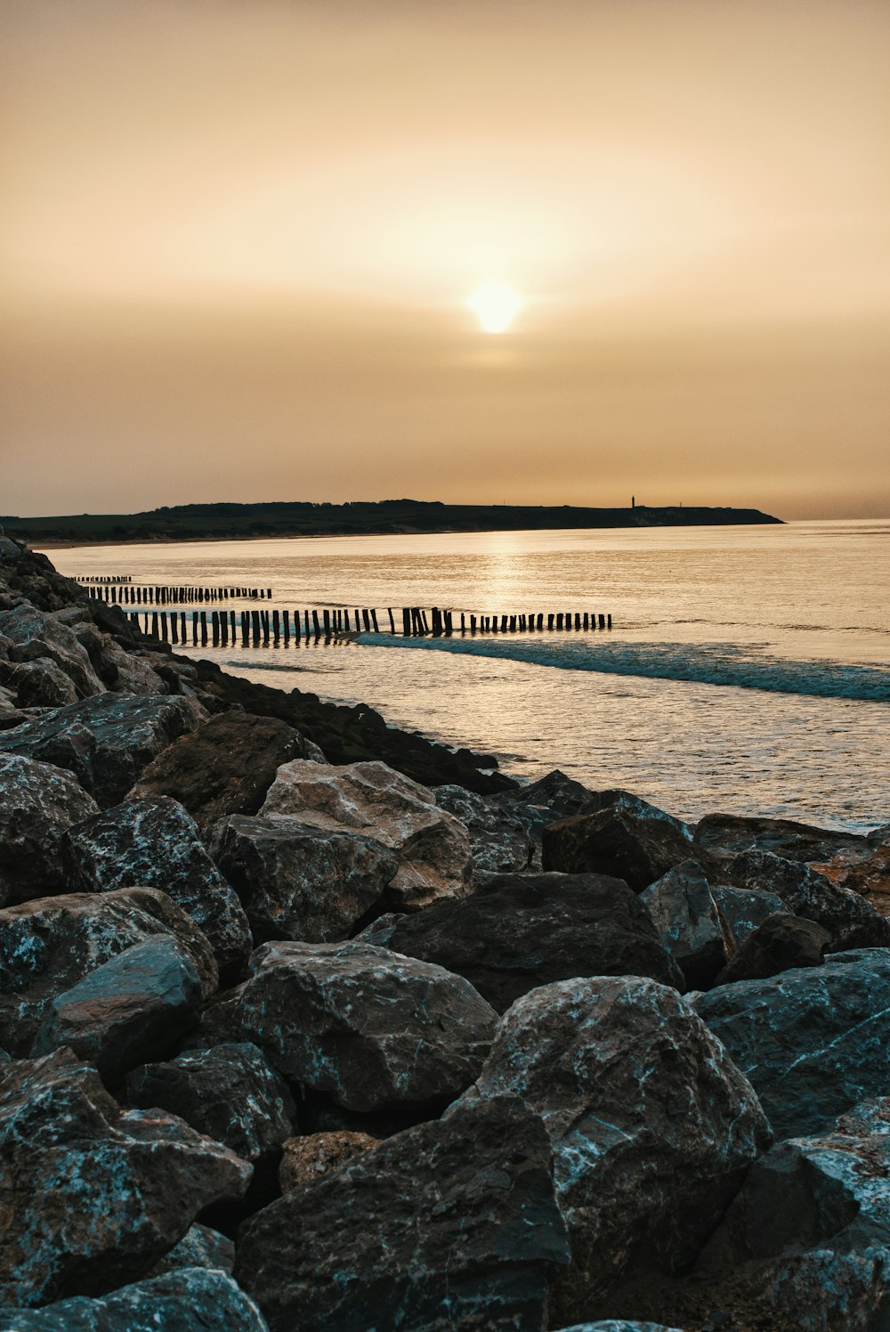 Quai en bois brun sur la mer au coucher du soleil