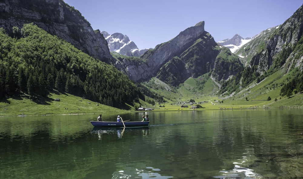 Barca verde sul lago vicino alle montagne verdi durante il giorno