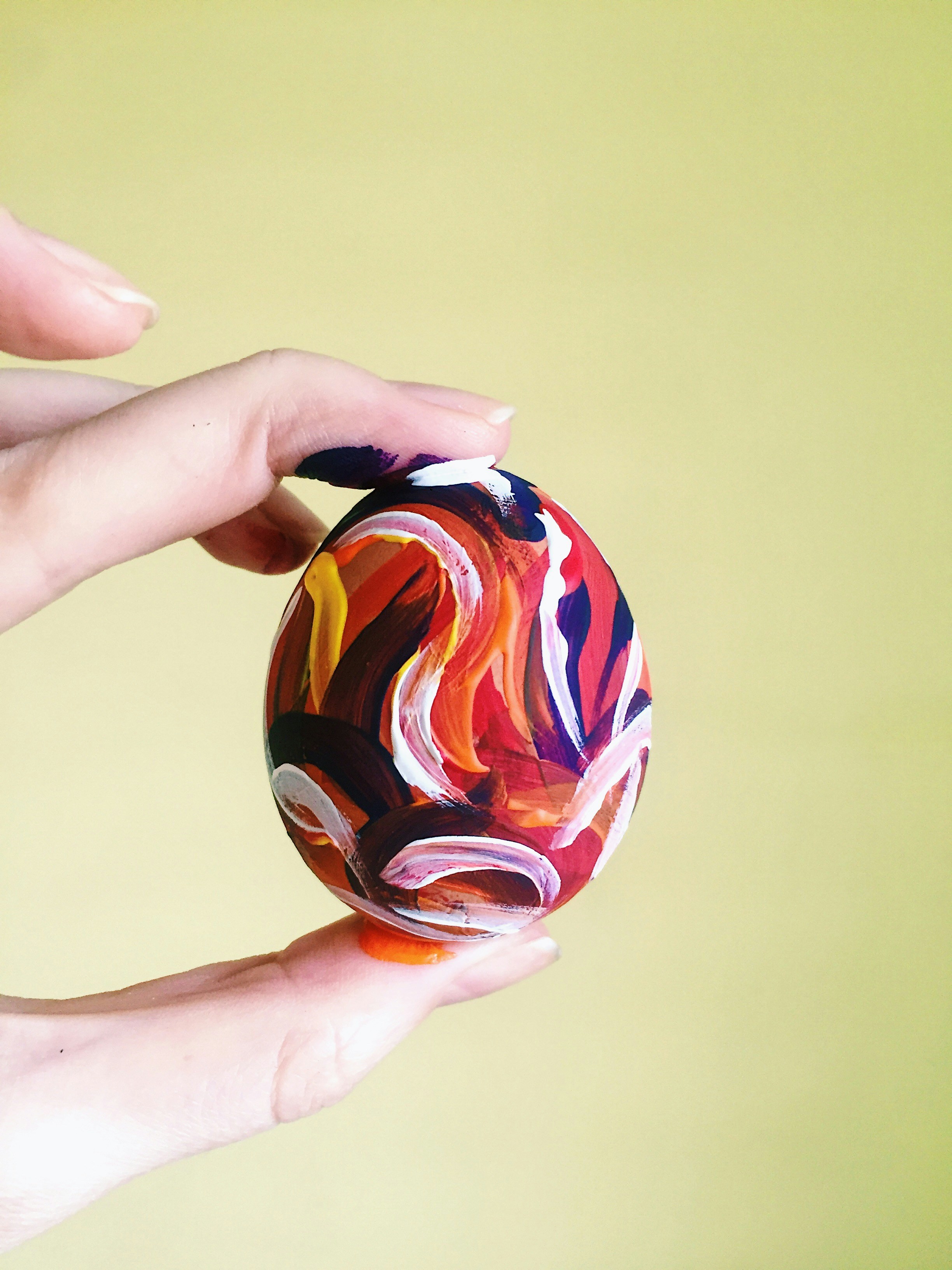 Person holding red blue and yellow ball