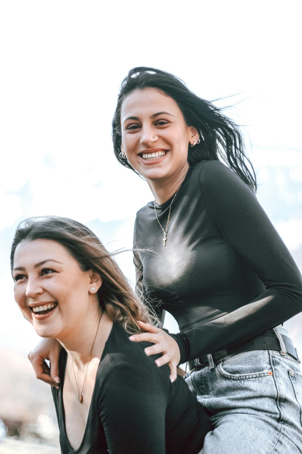 smiling woman in black long sleeve shirt beside smiling woman in black tank top