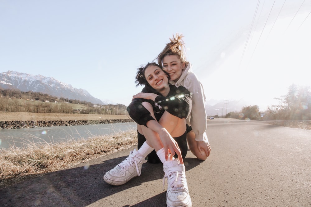 woman in white long sleeve shirt carrying girl in black jacket