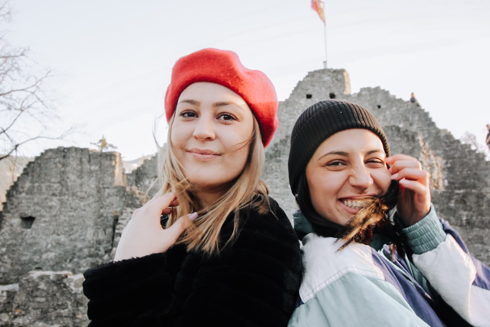 woman in black knit cap beside woman in white shirt