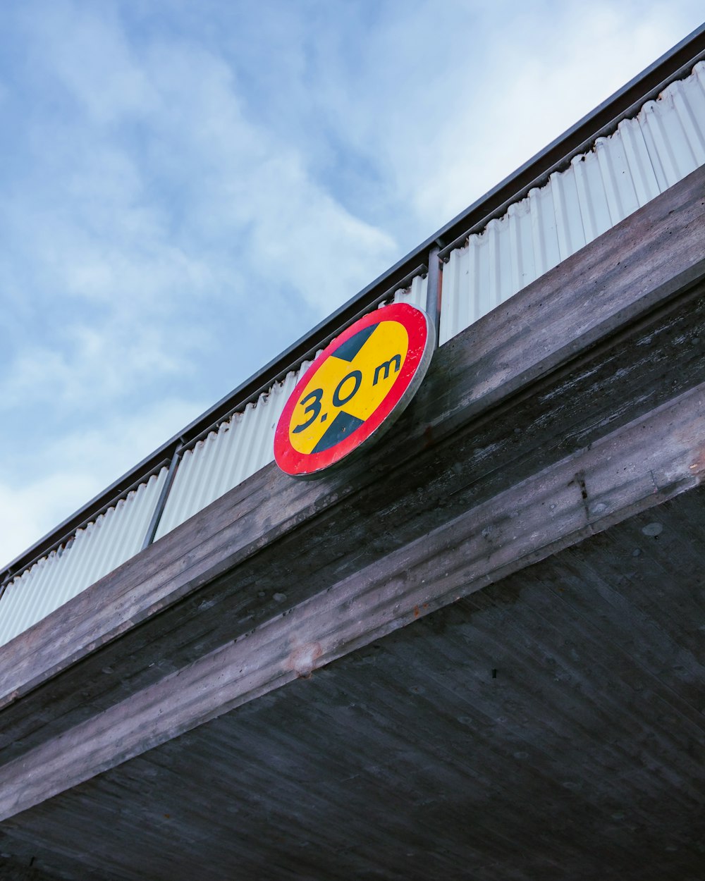 a red and yellow sign on the side of a bridge