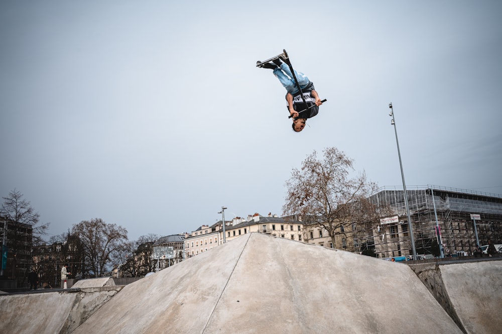 man in black jacket and blue denim jeans riding on black and orange snowboard during daytime