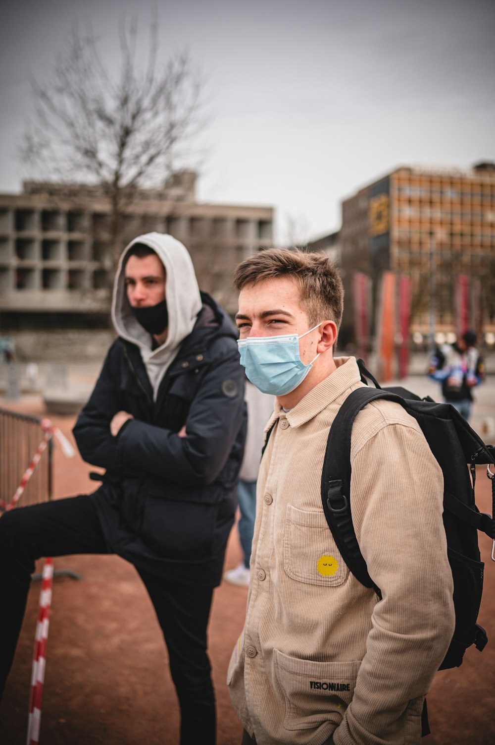 man in black jacket wearing white mask