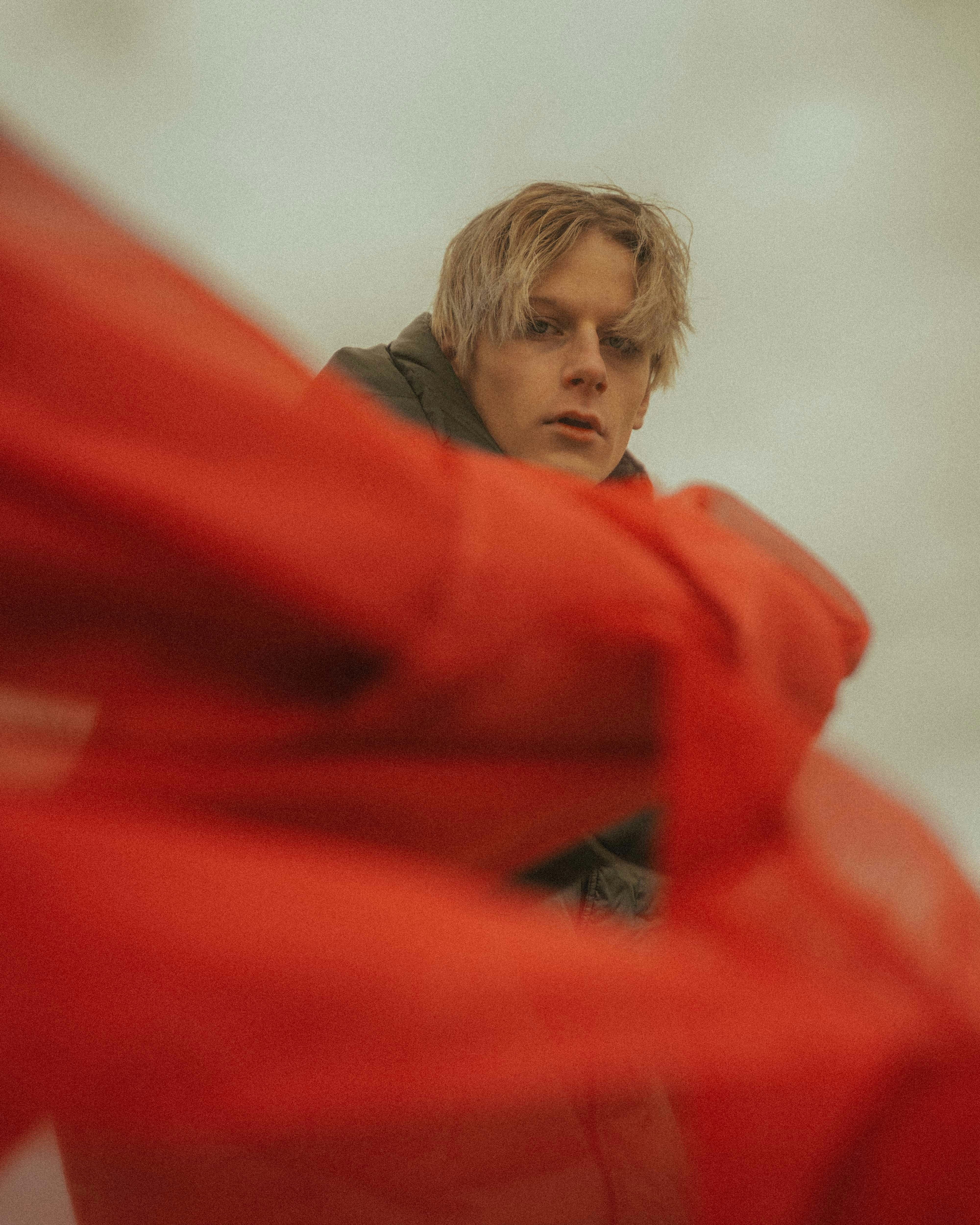 boy in red hoodie covering his face