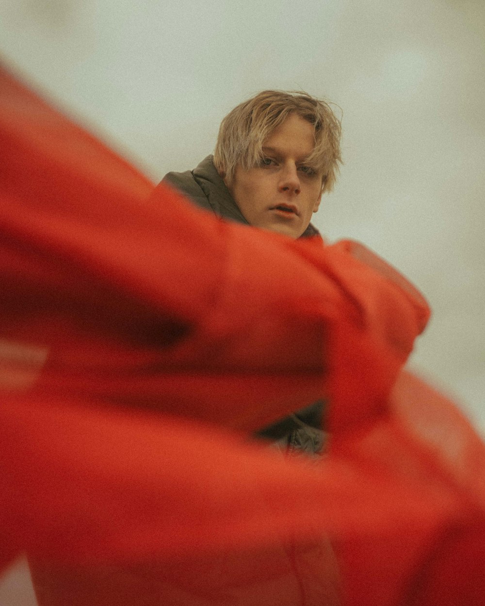 boy in red hoodie covering his face