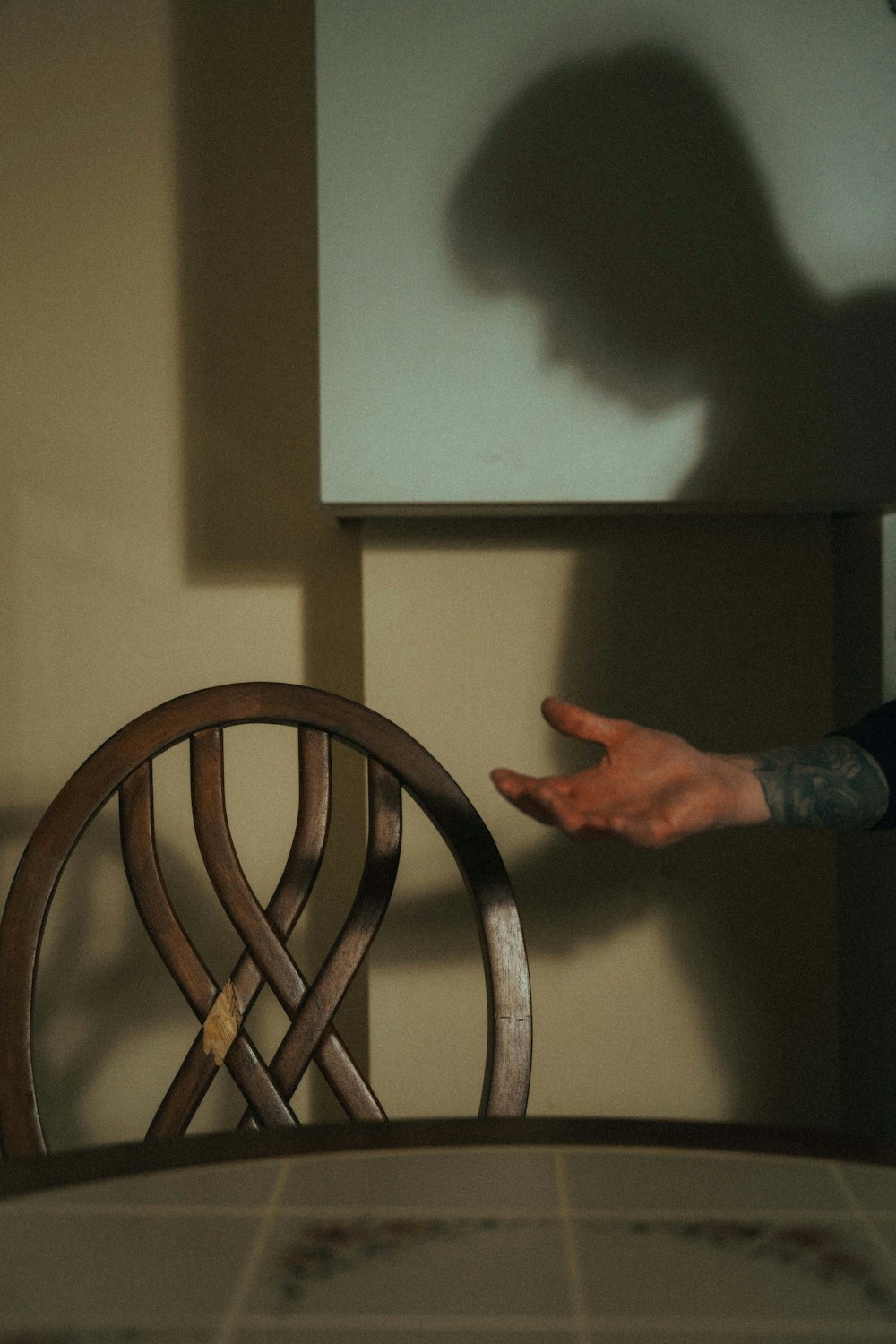 person in blue denim jeans standing near brown wooden chair