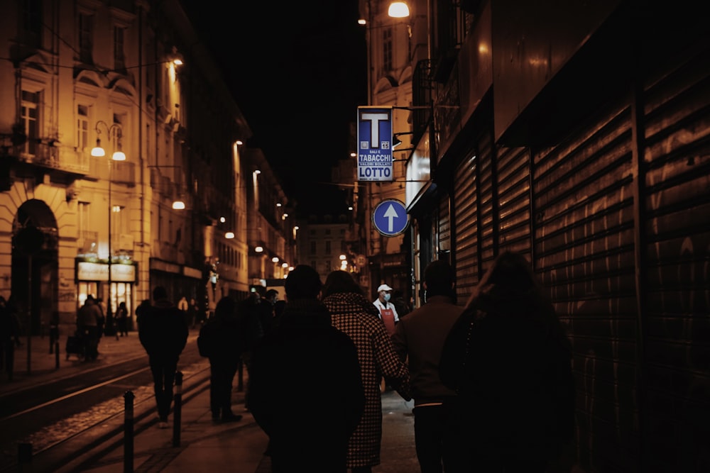 Personas caminando por la acera durante la noche