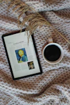 A cozy scene of a caregiver reading a comforting newsletter on a tablet.