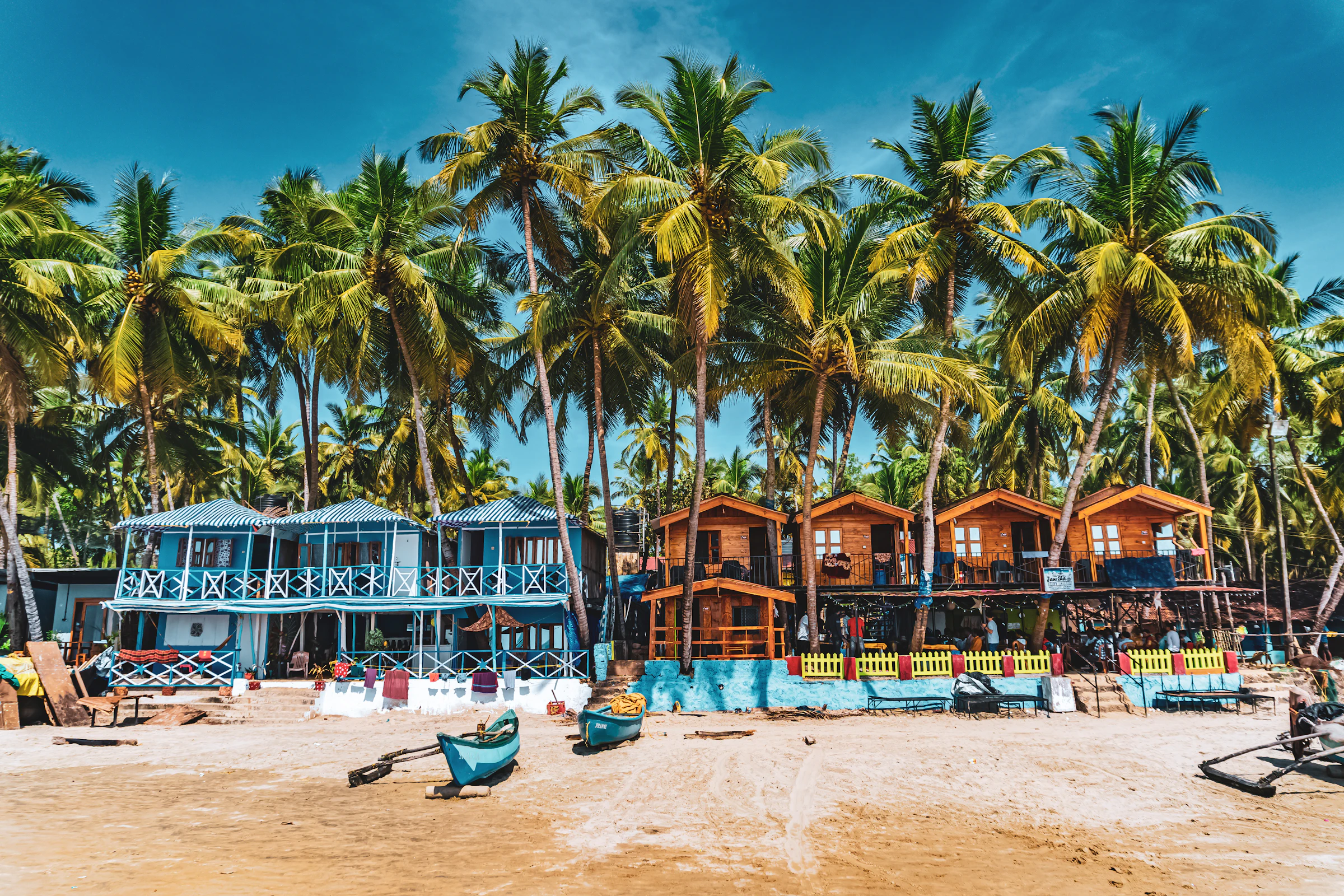 Colourful beach huts and palm trees on a Goa beach