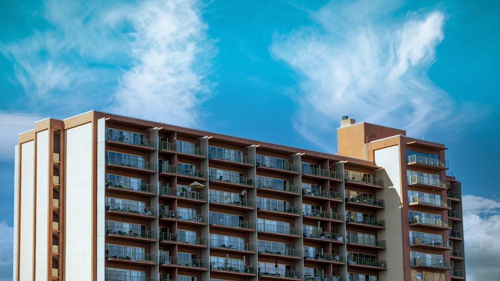 edificio in cemento marrone e bianco sotto il cielo blu durante il giorno