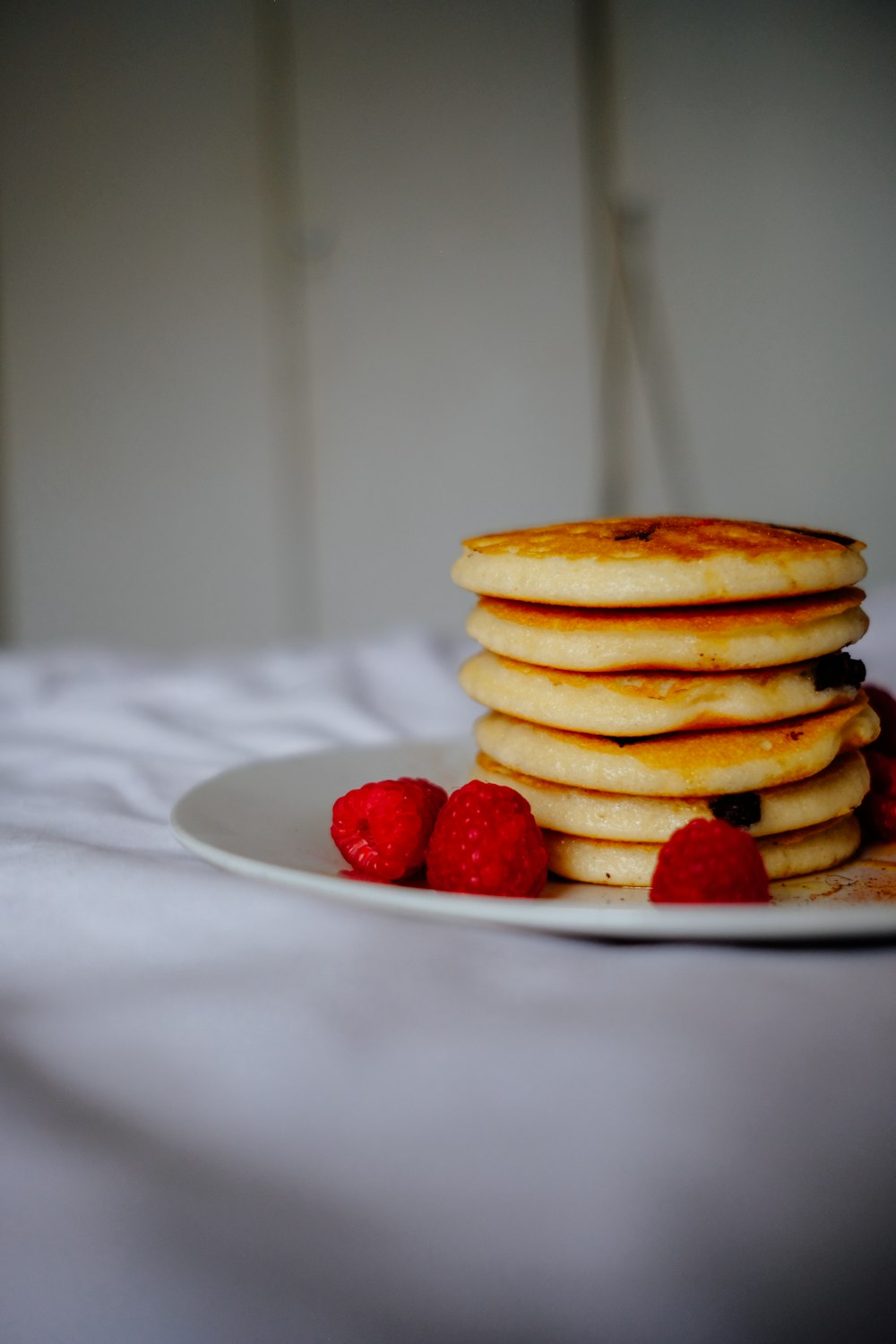 Pfannkuchen mit Erdbeeren auf weißem Keramikteller