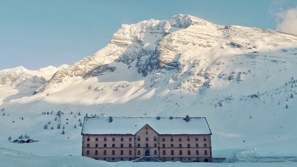 brown and white house near snow covered mountain during daytime