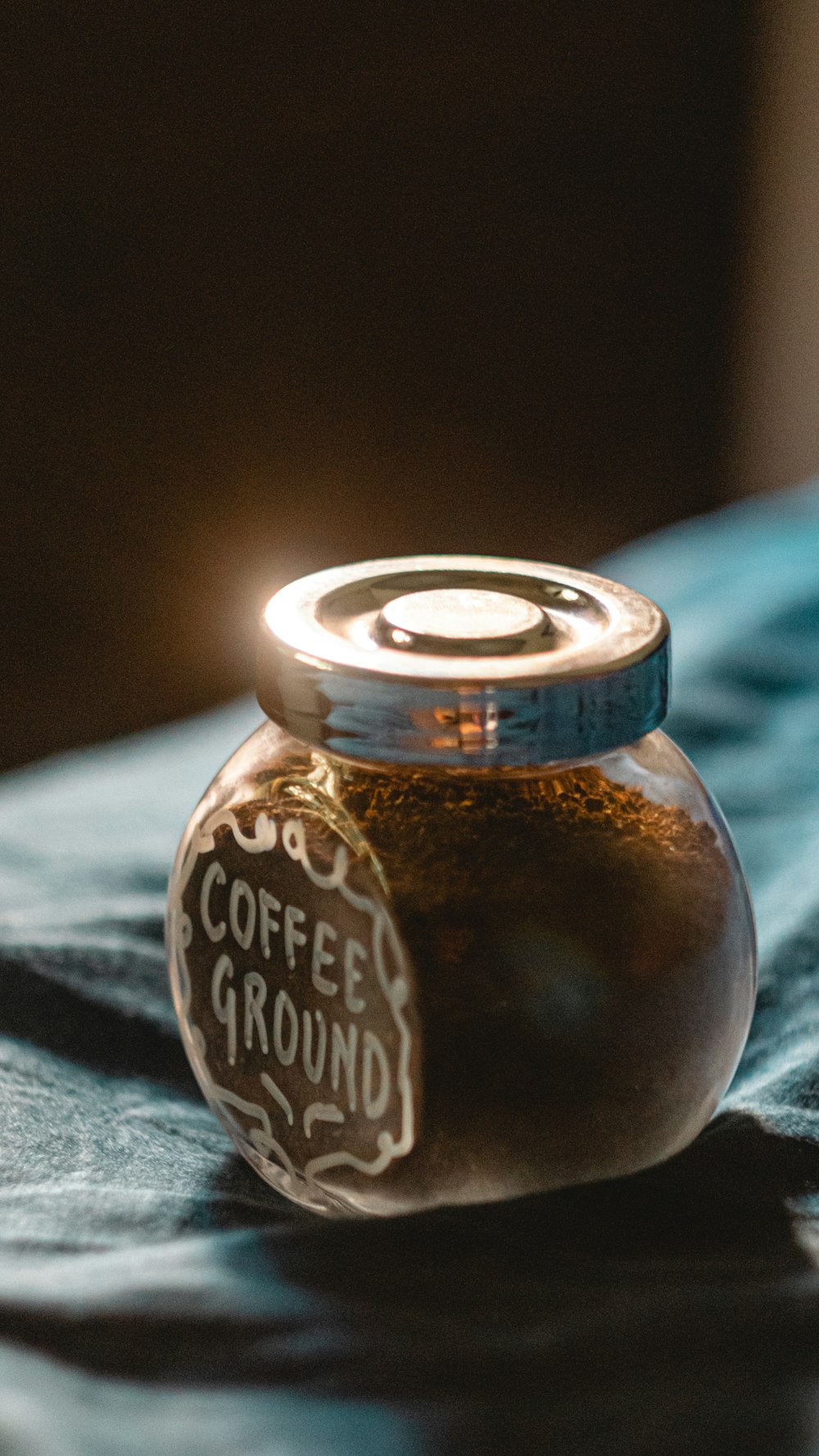 brown glass jar on blue textile