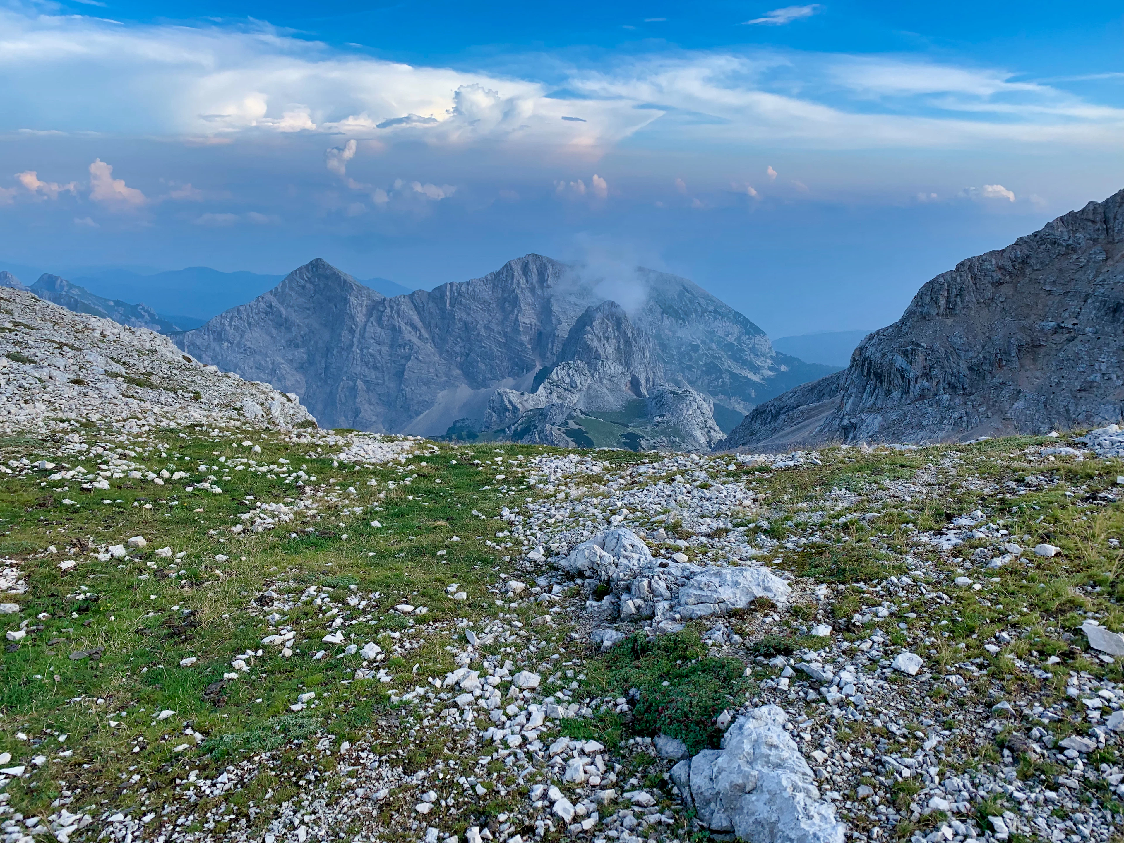 A stony high-mountain meadow and limestone peaks in evening light in the Julian Alps