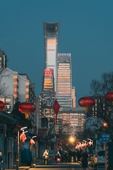 people walking on street near high rise buildings during night time