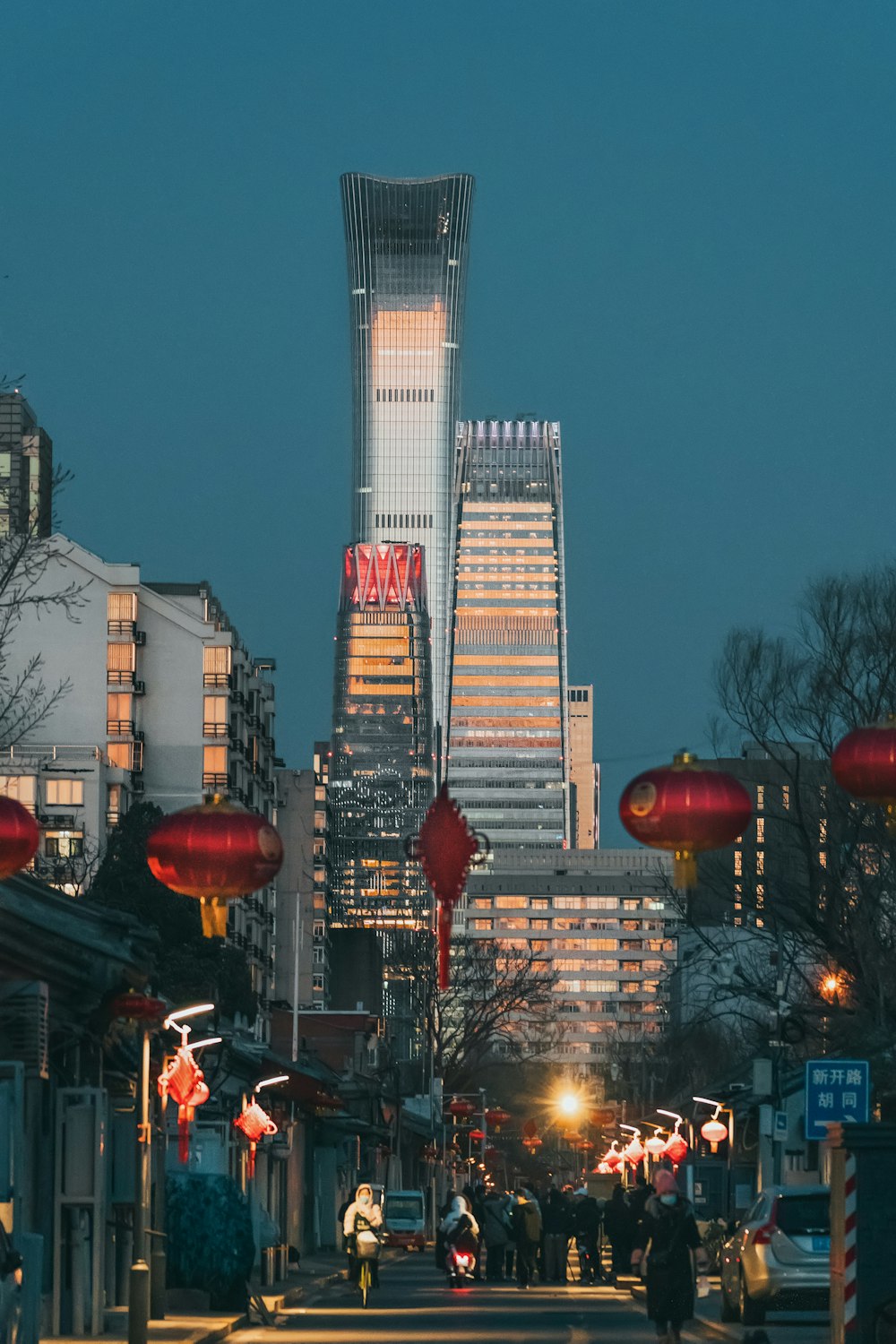 people walking on street near high rise buildings during night time