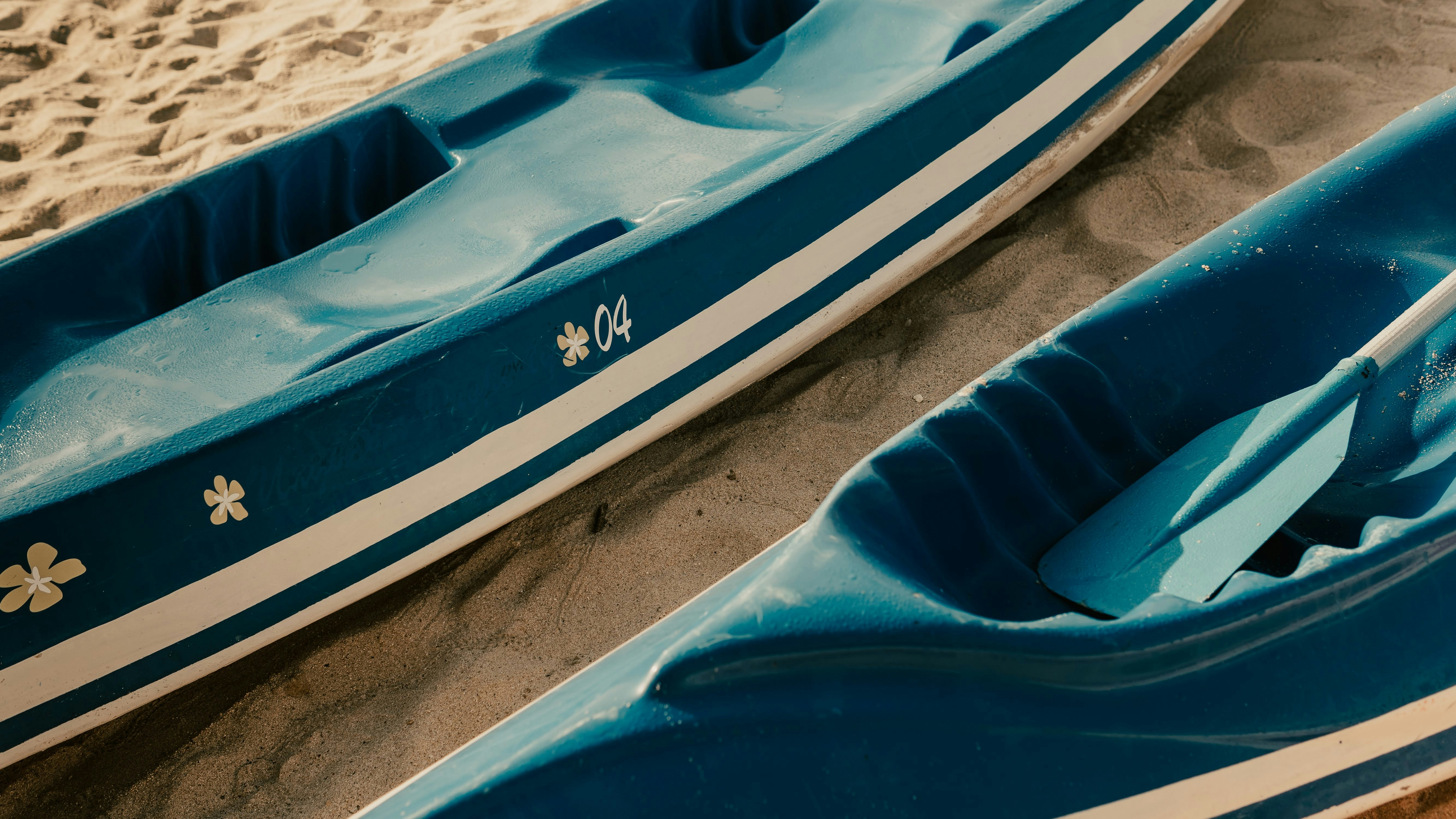 blue and white kayak on white sand during daytime