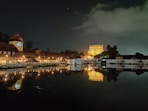 white and brown concrete building near body of water during night time