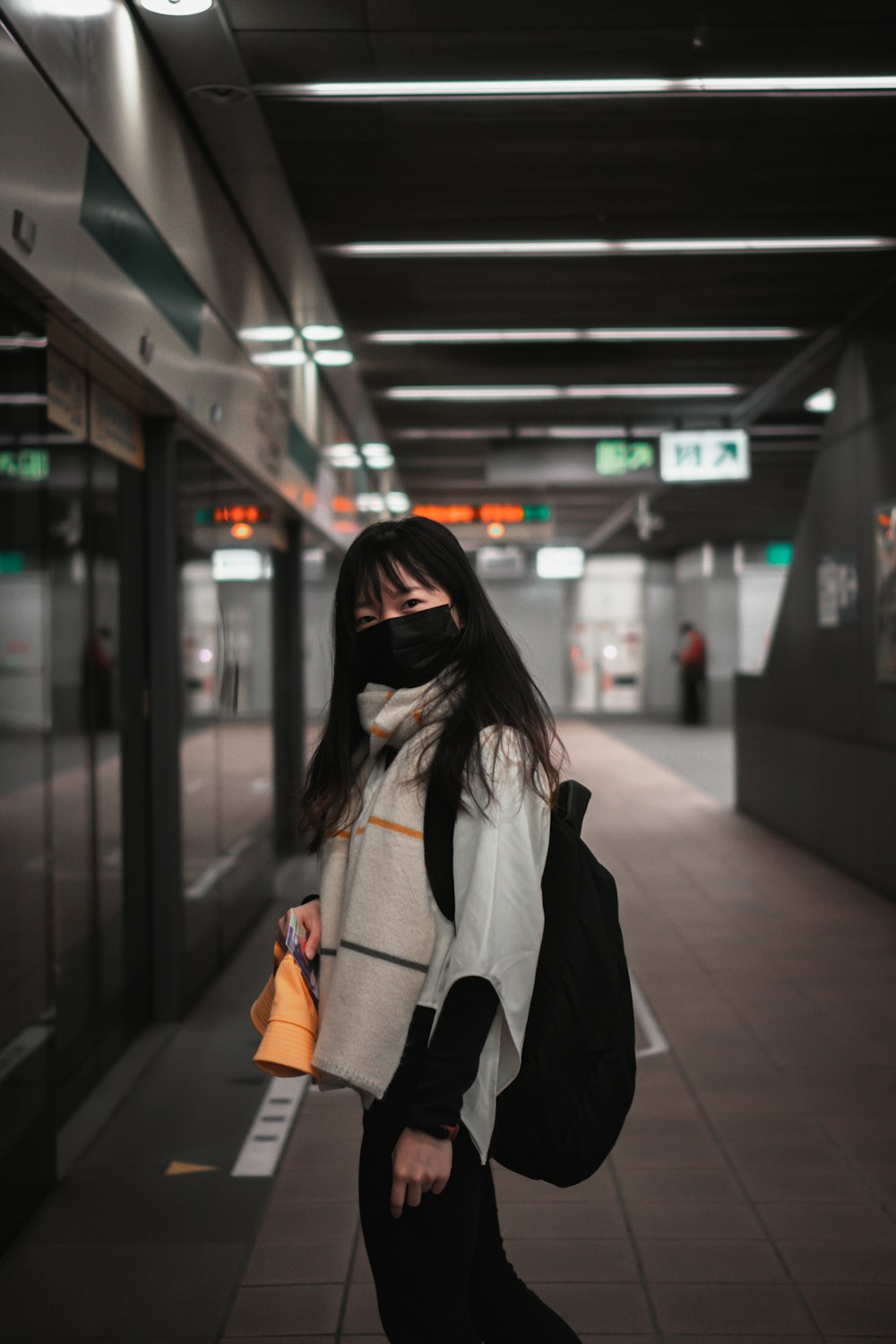 Woman in white and black jacket standing on the train station