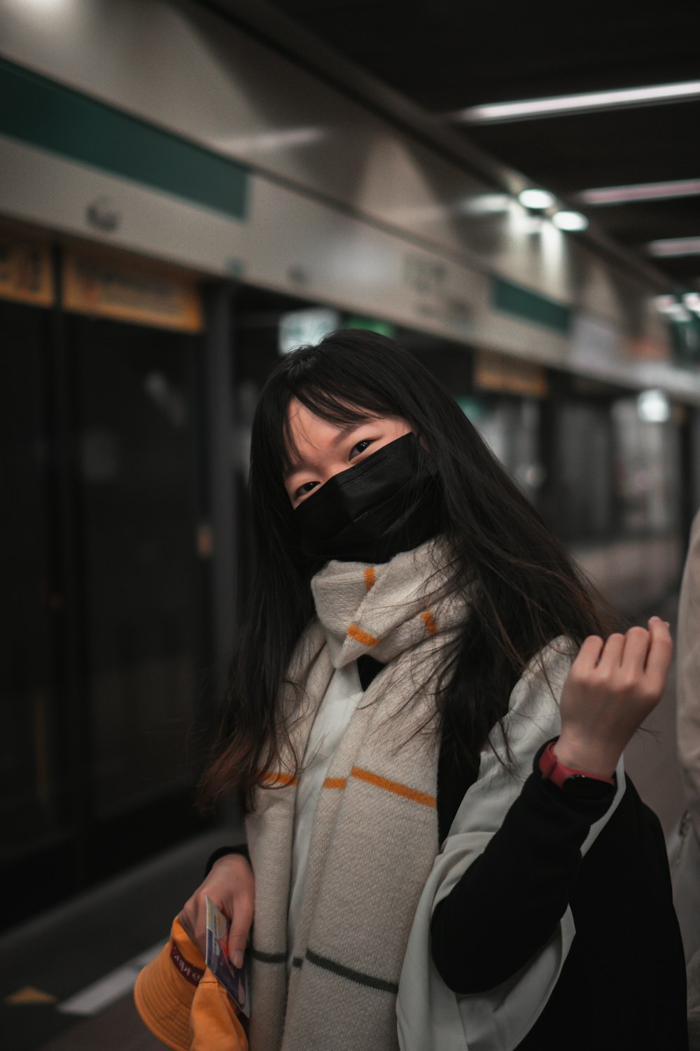 woman in black mask and gray coat