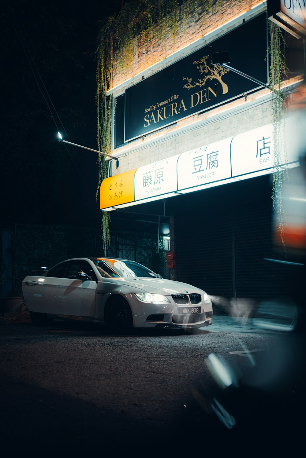 white sedan parked beside store during night time