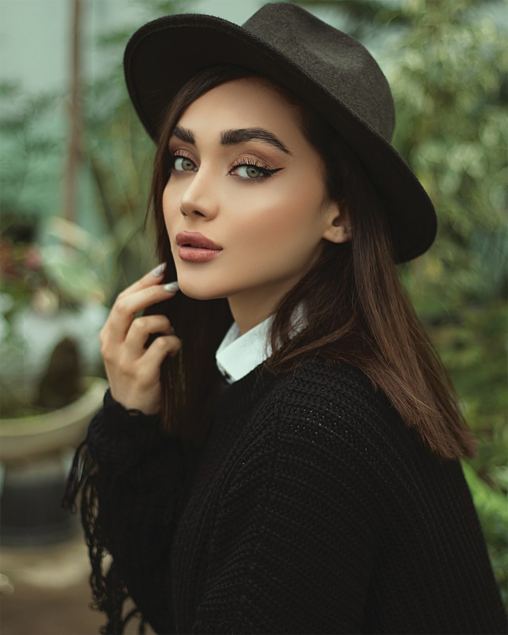 Frau in schwarzem Hut und schwarzem Pullover