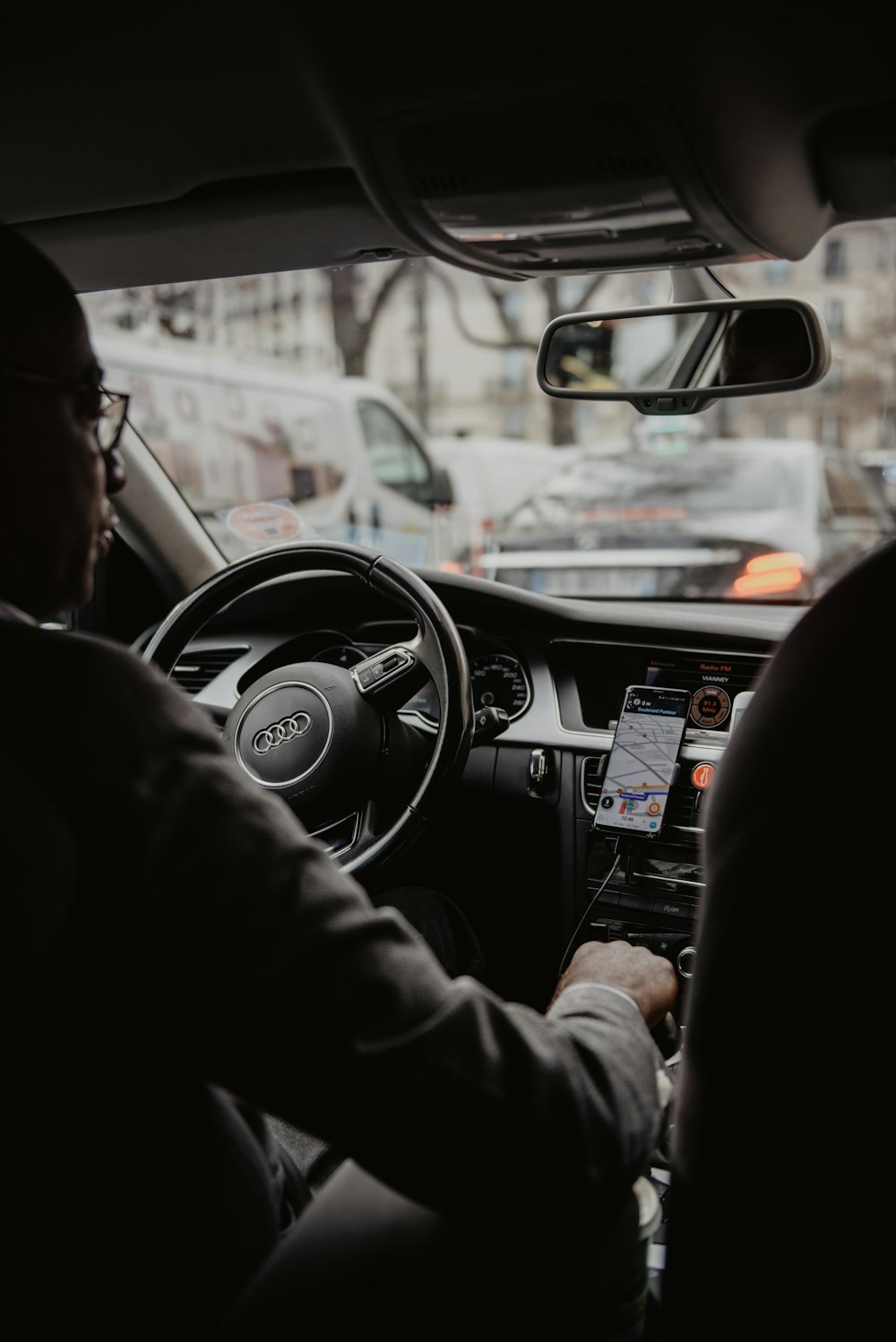 Hombre con chaqueta negra conduciendo coche durante el día