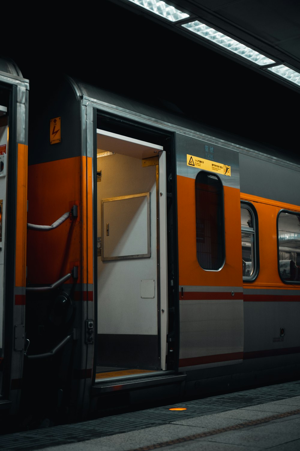 orange and black train in train station