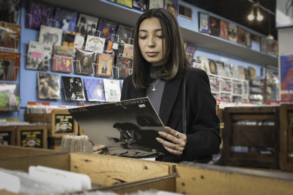 woman in black long sleeve shirt holding black and white book