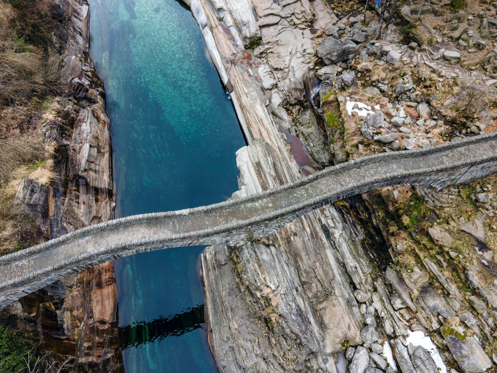 푸른 물 옆 바위 산의 회색 콘크리트 도로