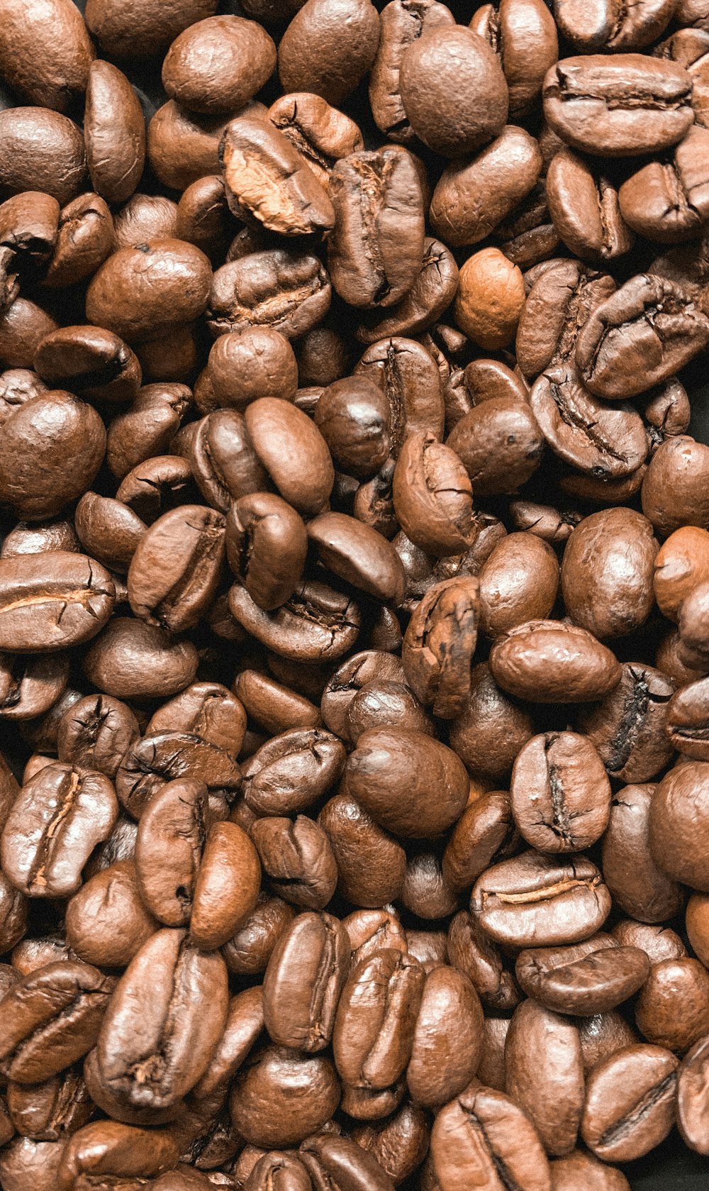 brown coffee beans on black surface