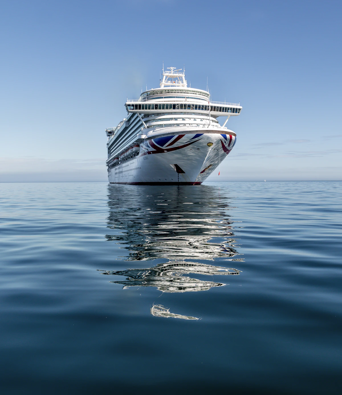 Large cruise ship sailing on open ocean under a clear sky