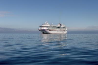 Passengers enjoying the deck of a small, affordable cruise ship under clear skies.