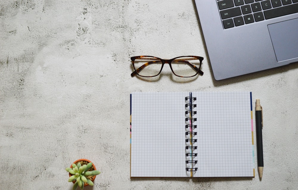 black framed eyeglasses on white notebook