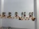 A line of small, handcrafted dolls dressed in traditional attire is displayed on a shelf. They are accompanied by an autumn-themed garland of orange and yellow leaves.